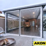 Clear vinyl roll-up curtains installed on a covered patio to block wind and weather while maintaining visibility.
