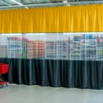 Retail Storage & Clutter-Hiding Curtains dividing a stock area from shopping aisles in a modern retail environment