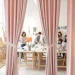 Art classroom with pink fabric curtains creating a bright and private workspace