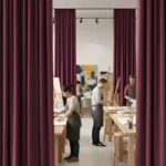 Artists working in a studio separated by maroon acoustic curtains