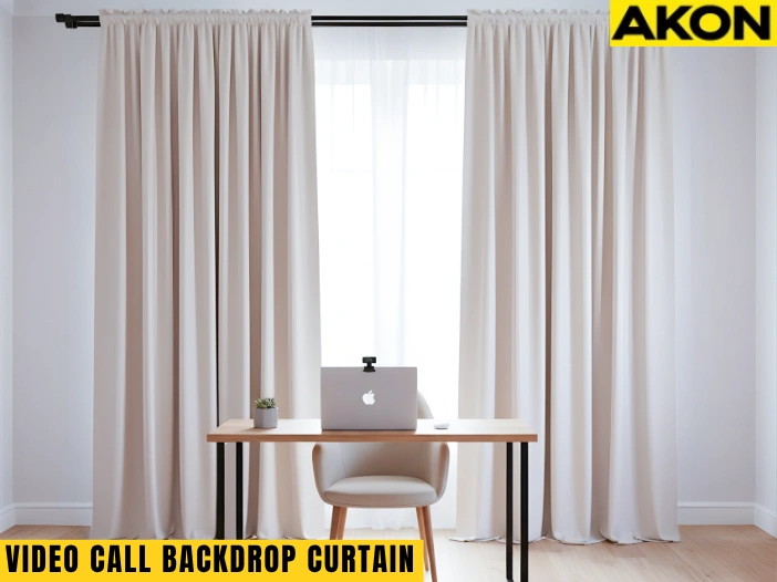 Beige video call backdrop curtain on a portable stand with laptop and chair in a home office