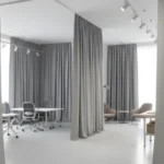 Black Fabric Enclosure Curtains in a factory setting, isolating machinery and work zones for improved safety and organization