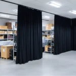 Black acoustic curtain walls dividing museum storage and display areas, improving sound isolation and layout flexibility