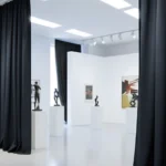 Black museum exhibit divider curtains defining art sections in a white contemporary museum space