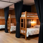 Black privacy curtains creating separate sleeping areas in a wooden bunkhouse at a retreat center