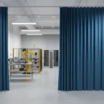 Blue Vinyl Fabric Enclosure Curtains in an industrial workspace, providing separation for equipment and reducing distractions