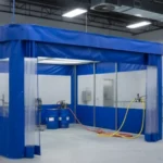 Blue curtain enclosure with clear upper panels inside a clean industrial workspace