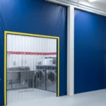 Blue vinyl enclosure with a clear center panel dividing the fire station laundry and cleaning area