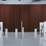 Brown Museum Exhibit Divider Curtains providing a warm backdrop for sculptures and framed art in a gallery exhibit