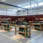 Brown modular curtain wall system creating a large woodturning work zone with several lathes and scattered wood chips on the floor