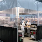 Clear and black vinyl industrial curtain enclosure in a stadium concession area, showing staff preparing food inside a protected space