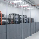 Clear vinyl partition walls creating an enclosed equipment area inside a clean, modern workspace