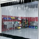 Clear vinyl strip curtain enclosure separating a fire station washdown and turnout gear cleaning area