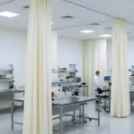 Cream UV-blocking fabric curtains dividing laboratory work areas while maintaining a sterile, professional environment