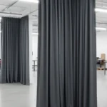 Gray Fabric Hallway Divider Curtains separating sections in a large, well-lit industrial space, providing flexible partitioning