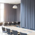 Gray divider Curtains for Camps and Retreat Centers used to partition a meeting or training room with tables and chairs