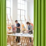 Green room divider curtains providing flexible partitions in an art classroom
