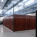 Large brown vinyl curtain wall enclosure forming a temporary multiuse room inside a correctional facility