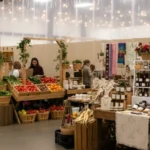 Light tan vinyl backdrop panels creating clean vendor sections inside an indoor farmers market and craft fair