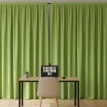 Lime green video call backdrop curtain on a portable frame with laptop and chair, suitable for online teaching
