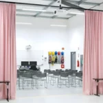 Pink training curtains forming a wide entry to an indoor safety classroom, used to separate space for confined-space training demonstrations