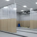 Tan and clear curtain dividers forming long enclosed bays in a large workshop