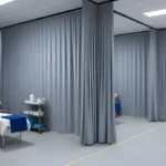 Temporary medical facility with gray modular curtain walls separating patient beds, creating private treatment zones for emergency or triage use