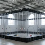 Transparent and black modular curtain RCdrone course – “Indoor RCdrone course with clear upper panels and black lower modular curtain walls, creating a fully visible yet safe track in a warehouse.”