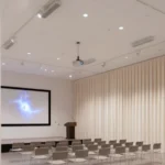 White curtain walls enclosing a planetarium-style presentation room, offering full blackout capability for visual clarity and comfort