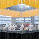 Yellow and clear vinyl industrial curtain setup in a stadium, allowing staff to safely serve food while keeping a clean, separated zone
