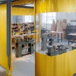 Yellow industrial curtain wall system forming a woodturning containment area with clear upper panels for visibility and chip control