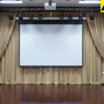 Beige curtains concealing AV equipment behind a presentation stage