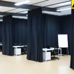 Black partition curtains used to separate work zones in a large open office