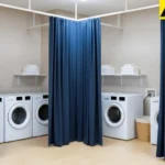 Blue fabric curtains providing separation between washers in a shared laundry room