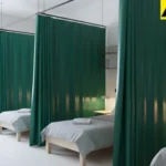 Curtain dividers separating multiple beds in a shared housing facility