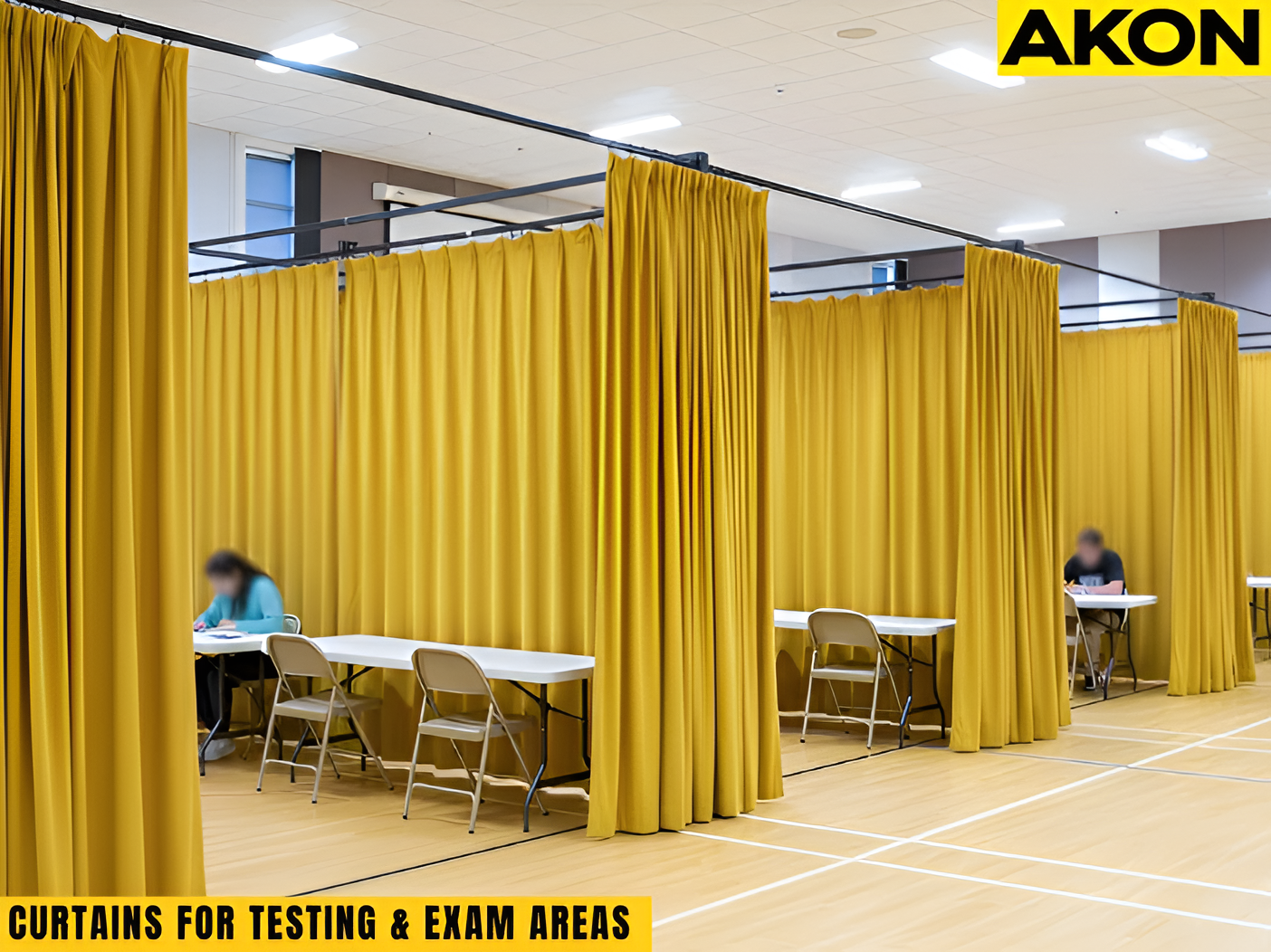 Curtains dividing a large gymnasium into individual exam stations for standardized testing.