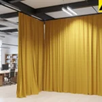 Floor-to-ceiling fabric divider curtains creating a flexible partition in an open loft office environment