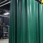 Green commercial curtains hiding AV equipment and cables in an event venue