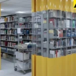 Library shelving enclosed with clear and yellow closet and alcove cover curtains