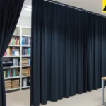 Office shelving concealed with black fabric closet and alcove cover curtains