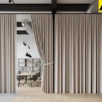 Soft fabric divider curtains used to section off areas in a high-ceiling loft workspace