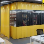 Yellow industrial curtain enclosure hiding IT servers inside an open office