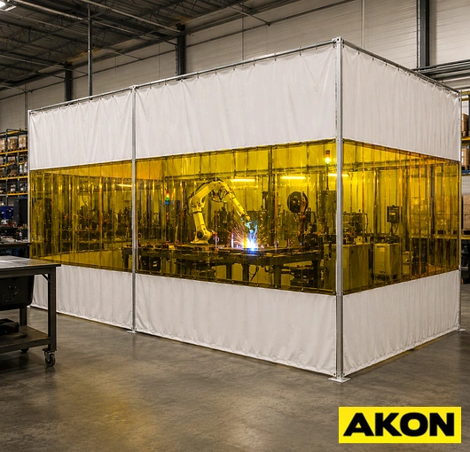 Freestanding industrial robotic welding cell enclosure used to contain sparks, fumes, and flash in a manufacturing facility.