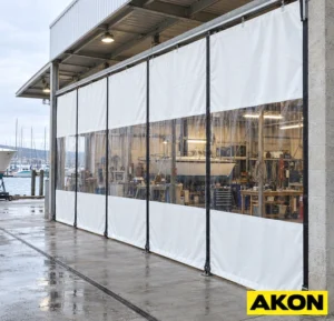 Heavy-duty industrial curtains installed in a large opening to block wind and drafts in a commercial or warehouse facility.